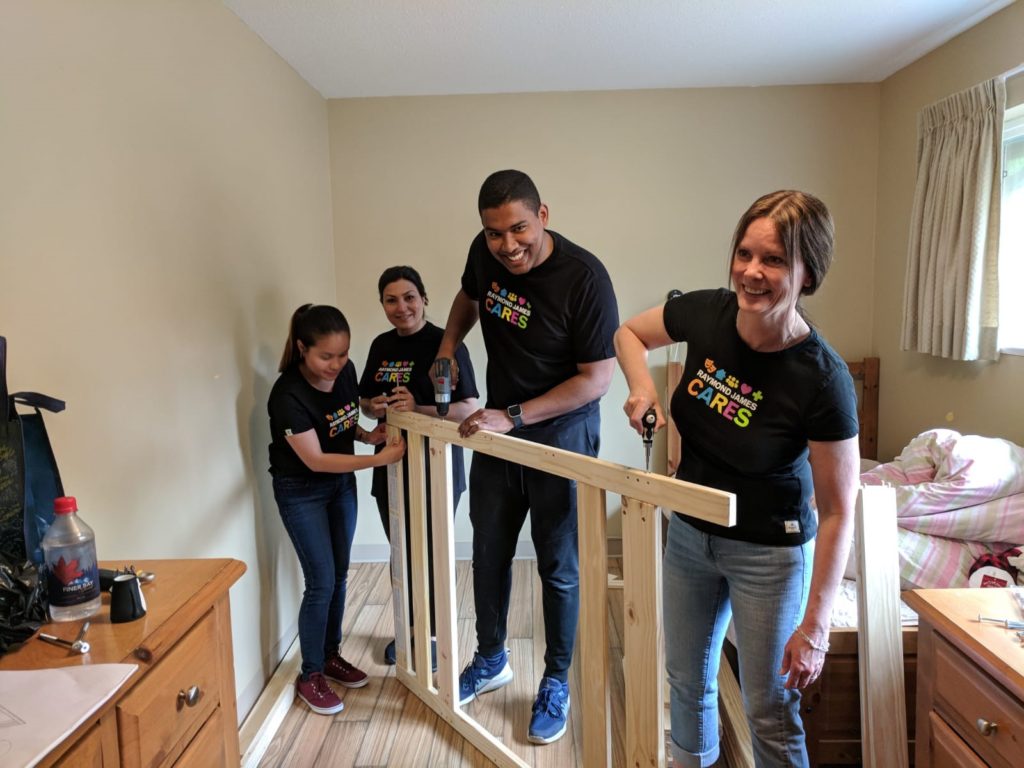 Raymond James Canada Foundation volunteers help assemble a bed at the Dixon Transition Society