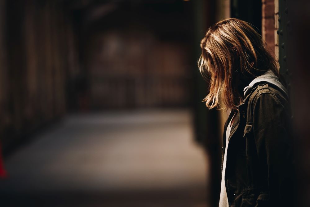 Sad woman  standing in an alleyway