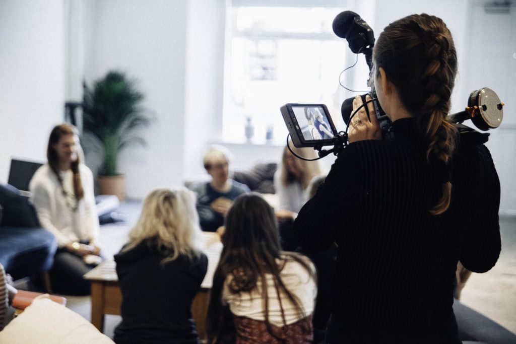 A Camerawoman films a group of people