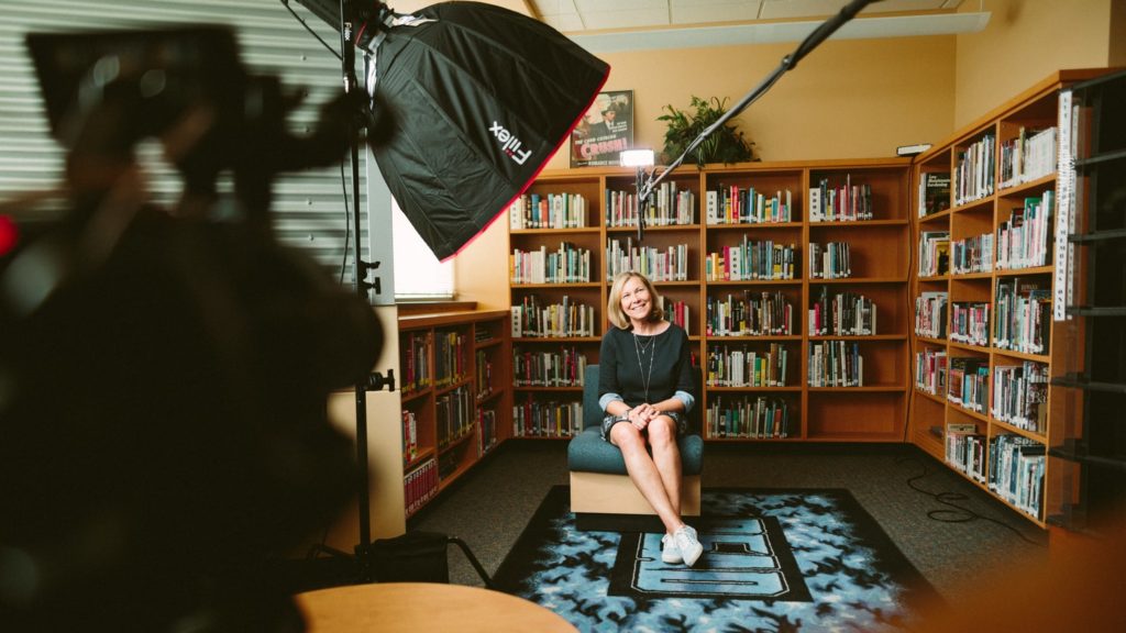 A woman is seated for an interview